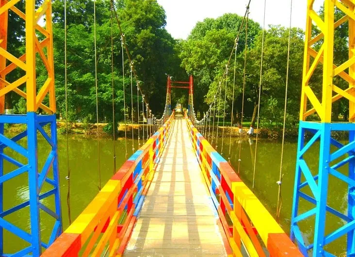 The colourful suspension bridge crossing Lunar Lake in the forest park